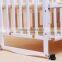 White adjustable baby cot with wiggler