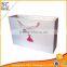 Custom White paper gift bags with die cut ribbon handles
