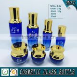 Bule colored glass cosmetic serum bottle and glass cosmetic cream jar with gold pump lid