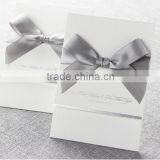 Elegant & romantic white pocket fold wedding invitation with silver bow & silver border