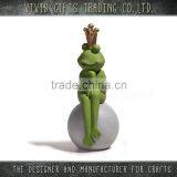 Ceramic or Porcelain frog with gold crown sitting on ball for home and garden decoration