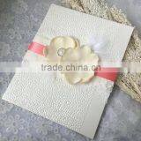 Noble & elegant white embossed wedding invitations with pink ribbons & feather decorations & floral decorations