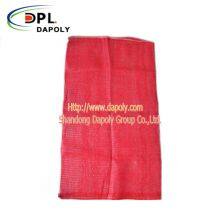 Aufgebot von Zwiebeln in leuchtend roter Verpackung, röhrenförmige Plastik-PP-Netzkartoffeltaschen thumbnail-3