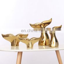 ceramic artwork of golden whale tail ornaments