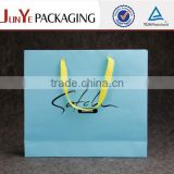baby blue art paper shopping bag with yellow twist handle