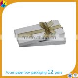 White elegant gift put it in a box tie it with a ribbon