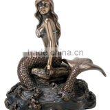 Bronze mermaid on rock sculpture