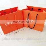 Wholesale orange paper bags in raw materials with handles