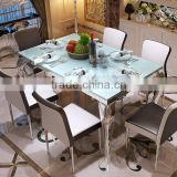Modern cream-colored glass top stainless steel frame dining table