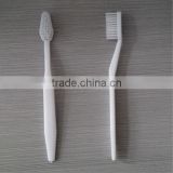 small white one time toothbrush with small toothpaste