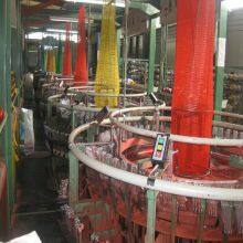 Aufgebot von Zwiebeln in leuchtend roter Verpackung, röhrenförmige Plastik-PP-Netzkartoffeltaschen thumbnail-5