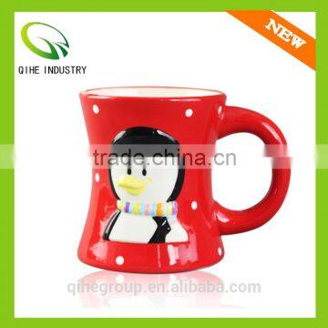 The red ceramic coffee mug with white speckle and penguin print