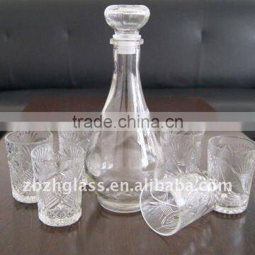 round clear glass wine bottle and cups