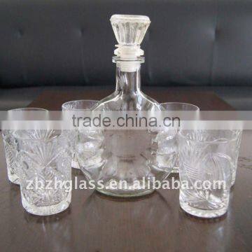 round clear glass wine bottle and cups