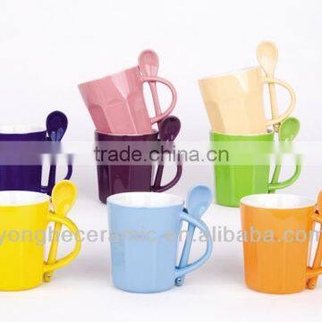 Bright-colored stoneware mugs with spoon