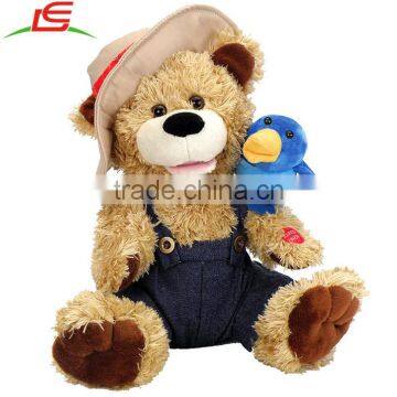 Stuffed teddy bear wearing cowboy hat with blue bird standing on shoulder