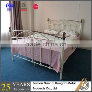 White wrought iron bed frame with brass