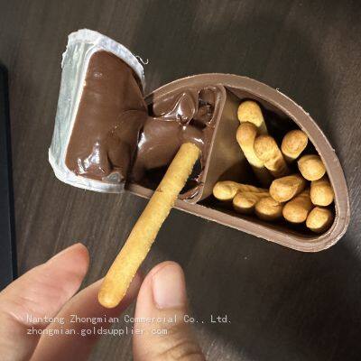Finger Biscuit mit hochwertiger Schokosoße in Bechern. Süßigkeiten. Weicher Schokodipbecher, Schokoladenkugeln und Schokoladengeldstücke