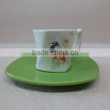 a set of small ceramic coffee cup with green saucer