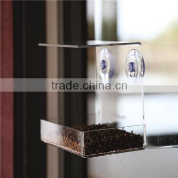 clear organic glass hanging bird feeder on window