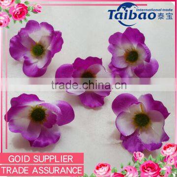 Event designer using purple poppy head decorative artificial flower garland making