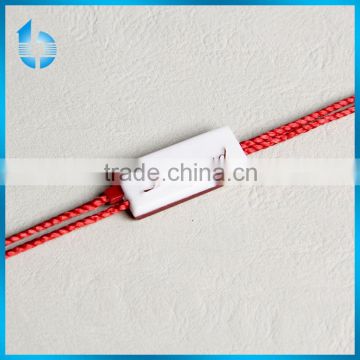 Durable plastic string buckle for garment hangtag