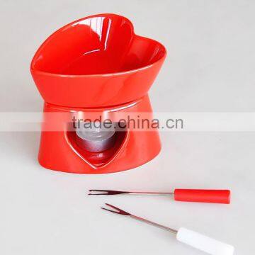 red color chocolate fondue set with forks and tea light