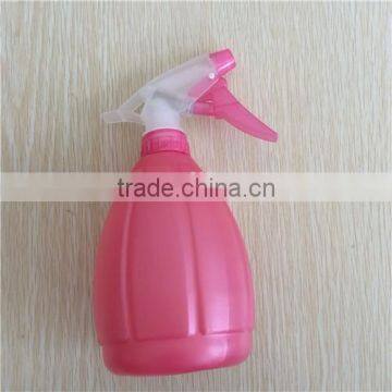 pink plastic garden spray bottle with trigger