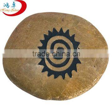 Natural engraved pebble stones etched with spiral sun