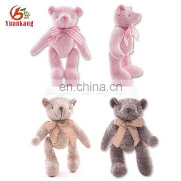 Cute knitted stuffed plush joint teddy bear in colorful sweater with movable arms and legs