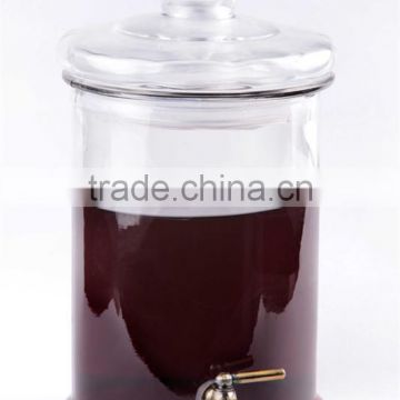 transparent round glass juice dispenser