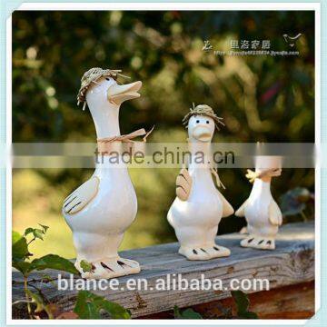 ceramic goose family figurine with straw hat