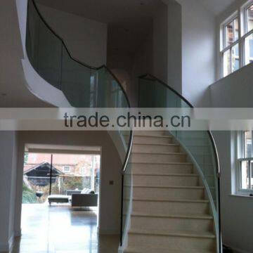 Helical sweeping staircase with marble treads structural glass and stainless steel handrail