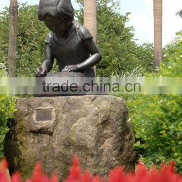 Bronze kid reading comic book sculpture