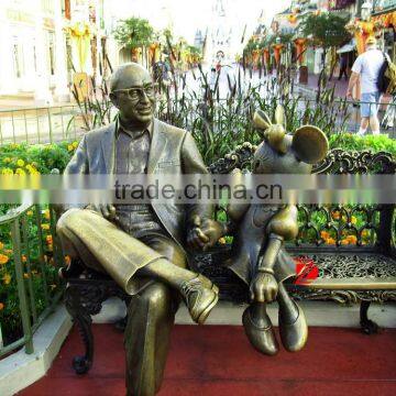 Famous bronze gentleman with mickey mouse statue sitting on bench