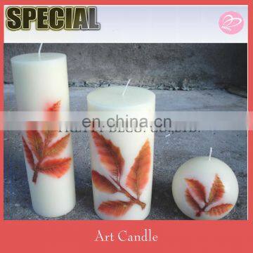 White pillar with orange leaf carved paraffin wax candle