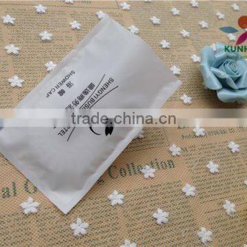 Guest room disposable shower cap with plastic wrapper