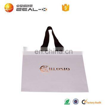 white paper bag with ribbon handle and embossed logo