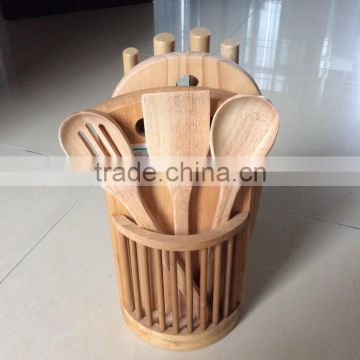 wooden knife block with three wooden utensils, four knives and 1chopping board