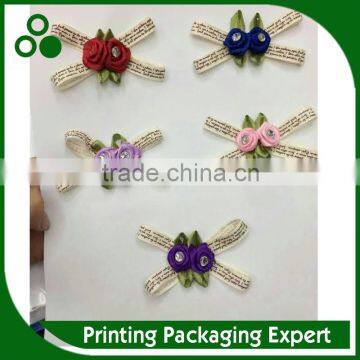 PRINTED RIBBON MADE BOW STICKED WITH DECORATIVE FLOWER