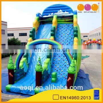 AOQI new style rainbow forest outdoor inflatable high slide with inflatable rock climbing wall for adults