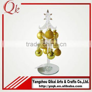 clear glass christmas tree with golden hanging ornaments