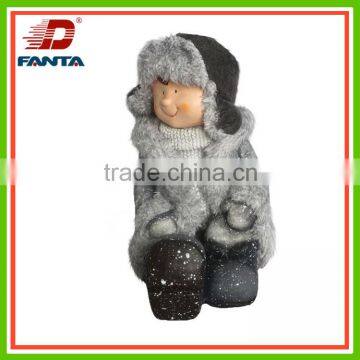 Magnesium sitting winter child with held cap