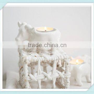 white ceramic candle holder with cow design cander stick