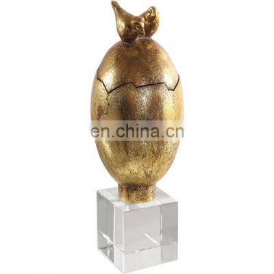 gold egg sculpture with acrylic base