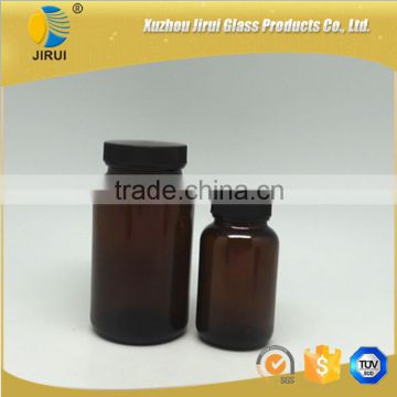 Amber vitamin pill glass bottle with lined black closure