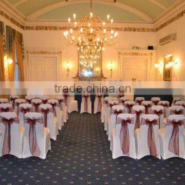 White spandex chair covers with organza sashes for wedding