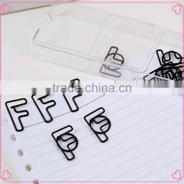 Office statinery black letter F shaped paper clips in transparent box