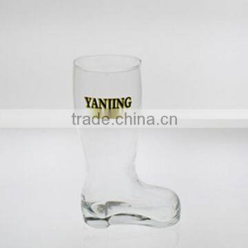 clear glass boot-shaped beer glass with decal