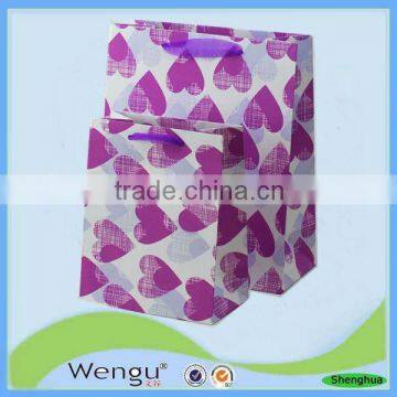 The latest design purple heart shape foaming gift paper bag with ribbon handle for packaging